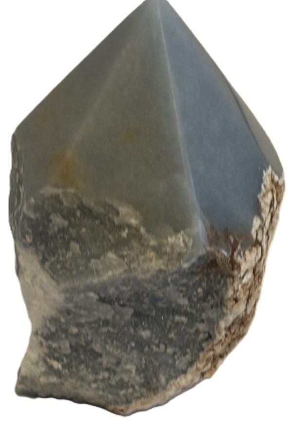 Natural rough angelite freeform with polished point 2 sians emporium Natural rough angelite freeform crystal with unpolished sides and a smooth polished blue point standing on a white background